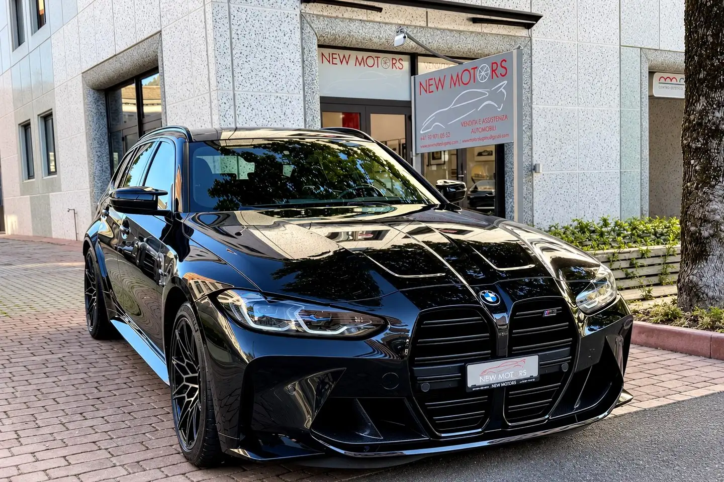 La BMW M3 Touring nera davanti all’ingresso dello show-room New Motors